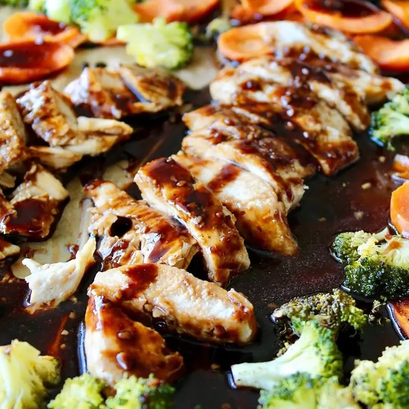 Four different sheet pan dinner combinations including salmon with asparagus and sausage with bell peppers