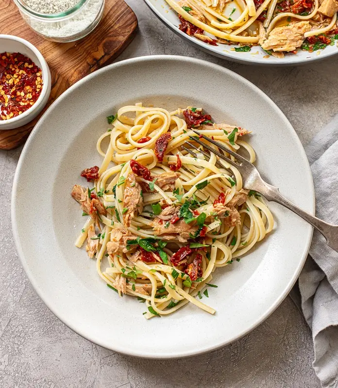 A plate of canned tuna pasta with garlic olive oil and lemon juice, a budget friendly dinner for students
