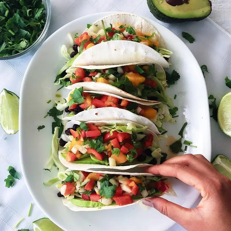  Warm tortillas filled with seasoned beans shredded cheese and salsa, a simple and cheap taco dinner for college students