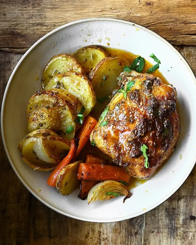 Step-by-step preparation of a sheet pan dinner with raw chicken and vegetables arranged on a baking sheet