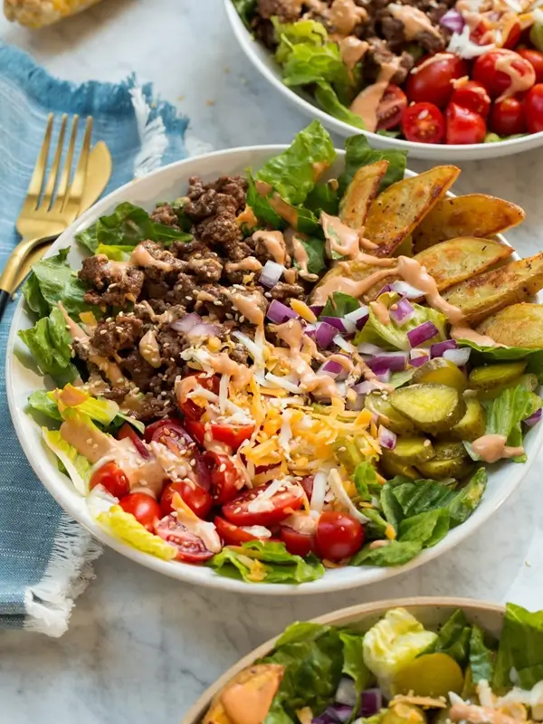 Pressing ground beef onto a hot cast iron skillet to create a crispy smash burger crust
