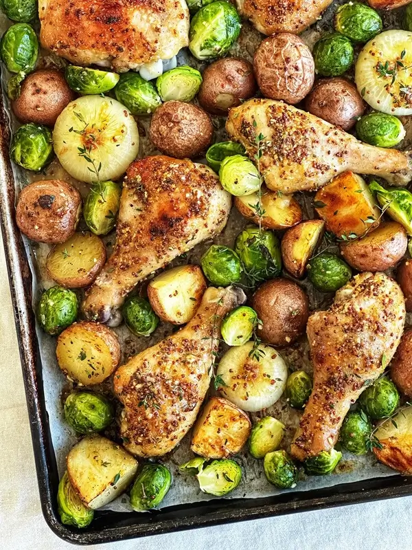 Cubed baby potatoes and fingerlings roasting alongside chicken on a sheet pan with no additional pots used