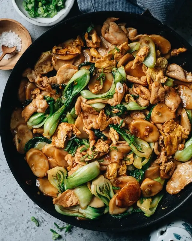 A pan of soft tomato and scrambled egg stir fry with soy sauce served over white rice, a cheap student dinner idea