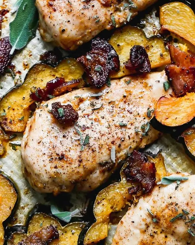 A rimmed baking sheet with roasted chicken, potatoes, and vegetables as an example of a sheet pan dinner